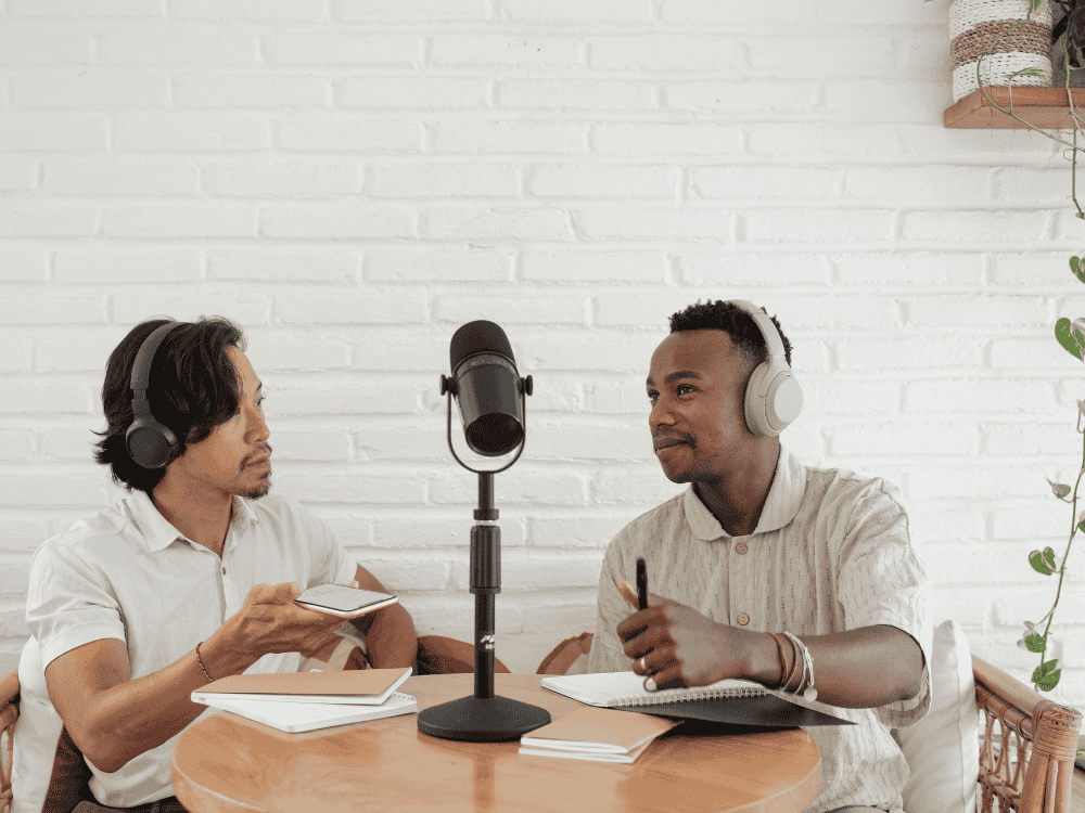 2 male podcasters recording using a podcast microphone